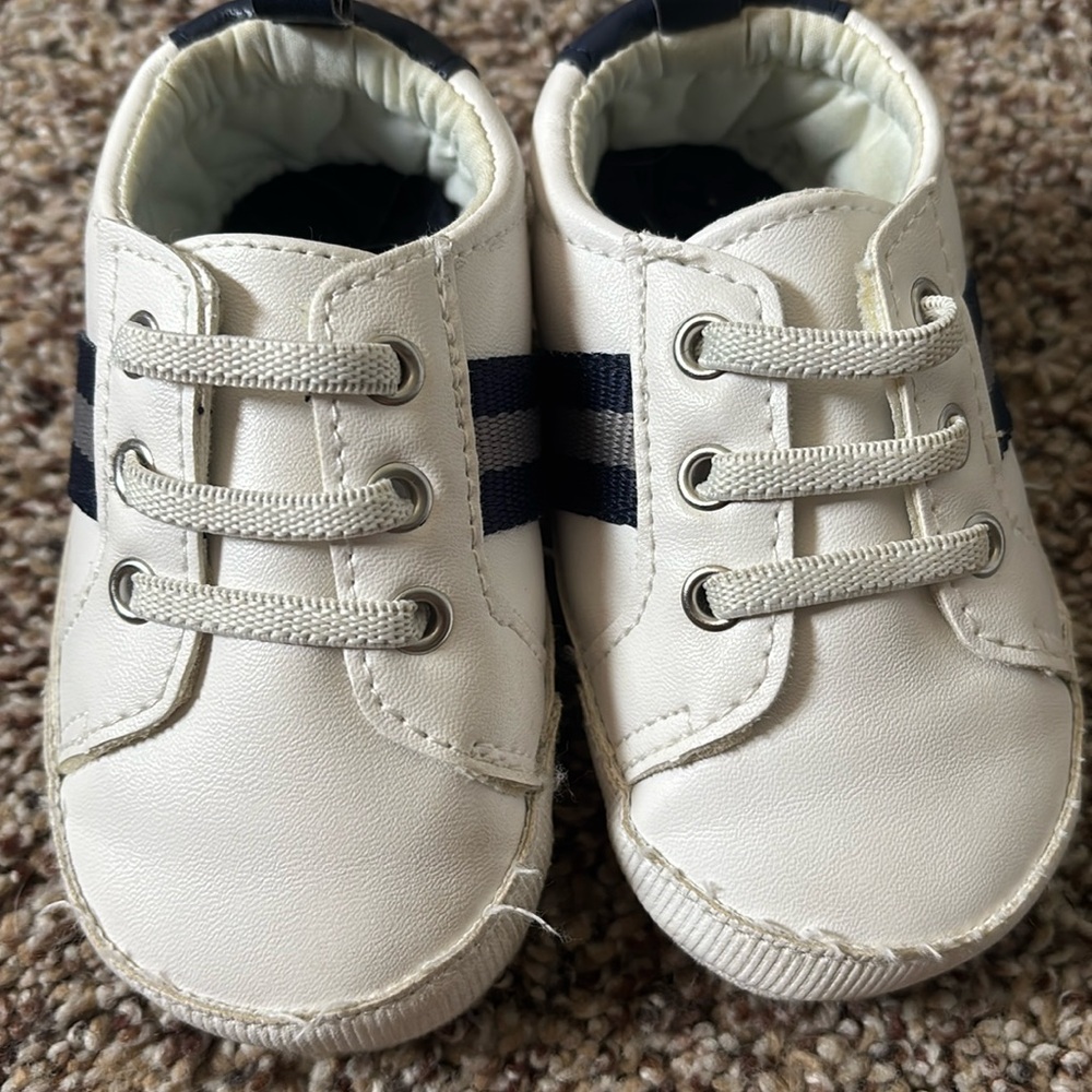 Carters 6-9 month baby shoes. White with blue and grey stripe on the side.